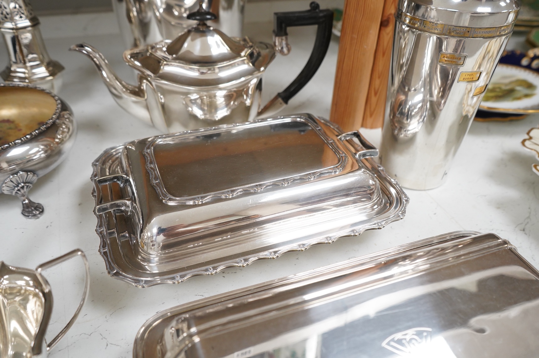 A collection of plated wares to include a vintage cocktail shaker with recipes, wine cooler and two plated entrée dishes including Art deco, largest 29cm wide